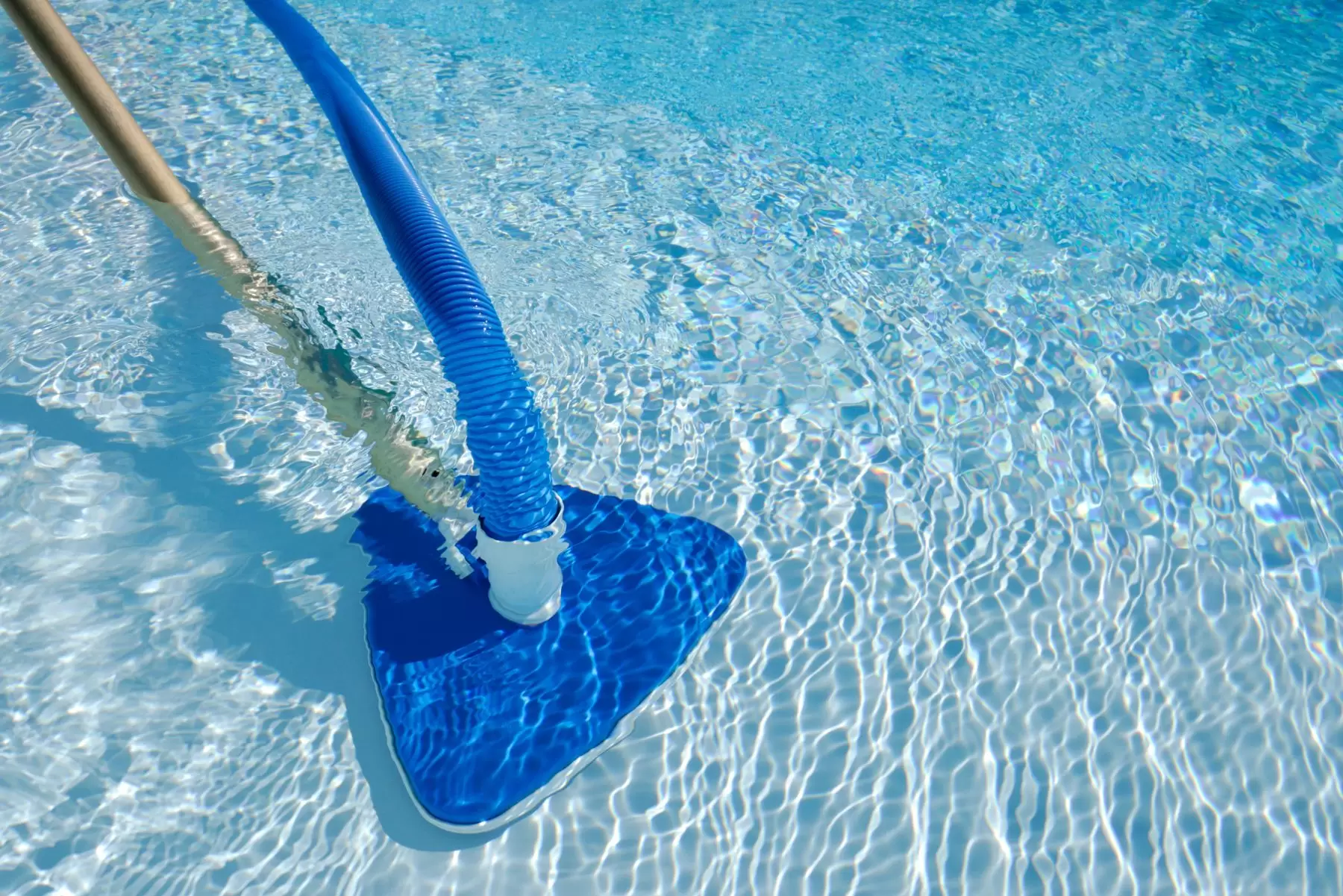 Aspirapolvere in azione che pulisce il fondo della piscina